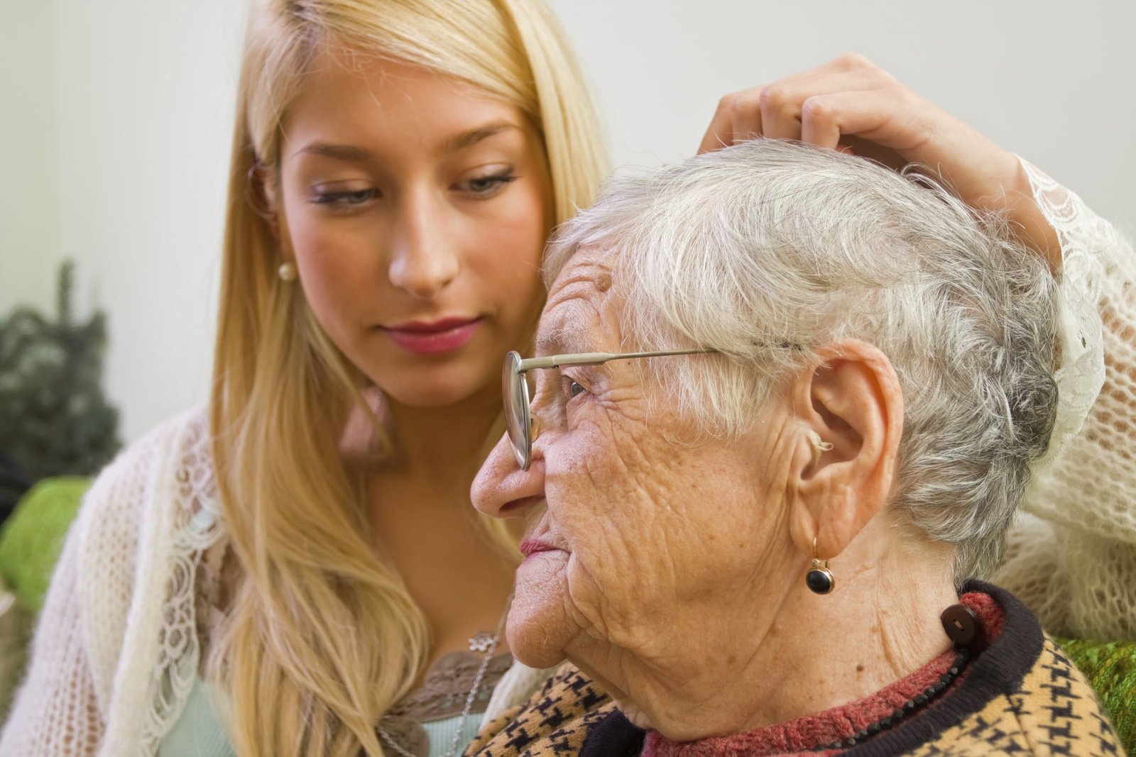 A young woman pating an older one whit trust and empathy (focus on the old woman) - part of a series.