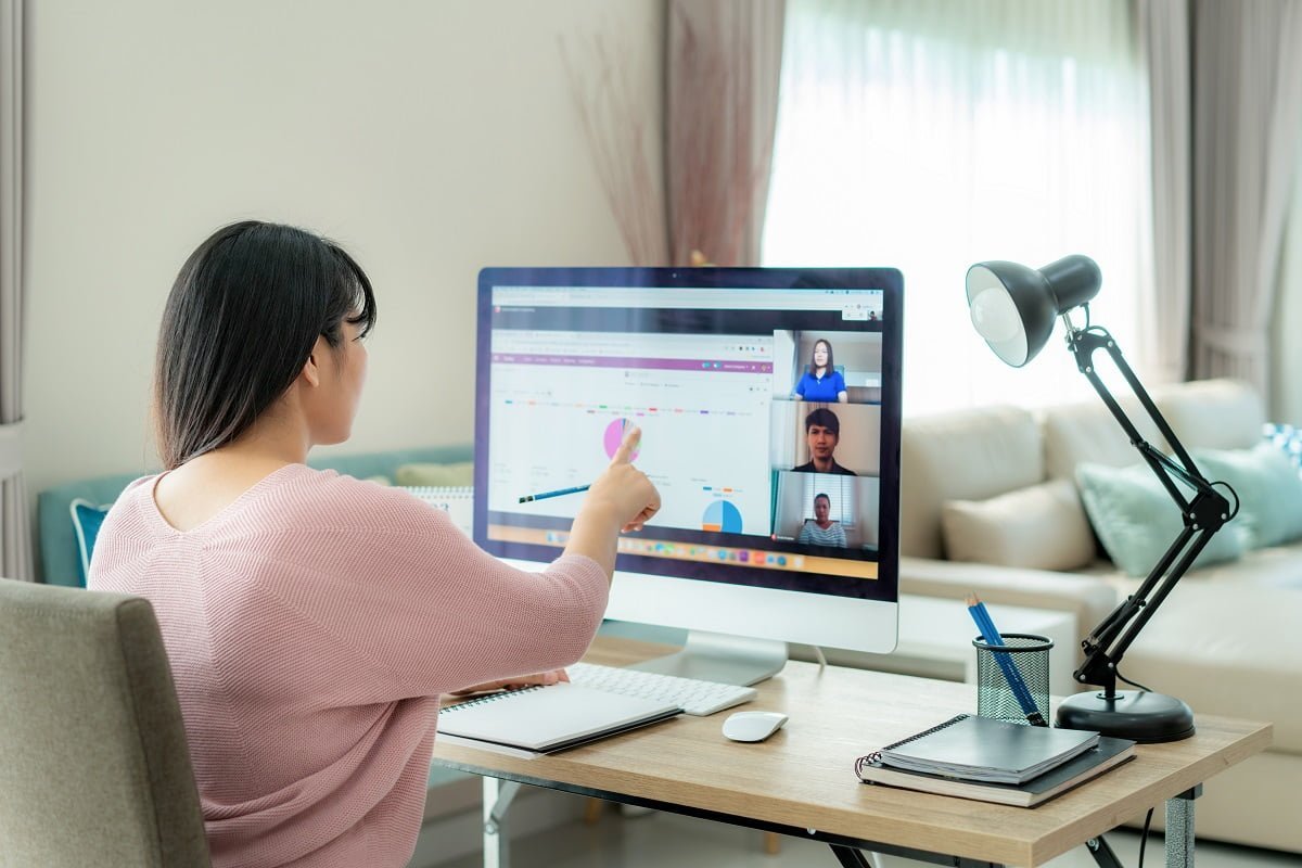 Asian business woman talking to her colleagues about plan in video conference. Multiethnic business team using computer for a online meeting in video call. Group of people smart working from home.