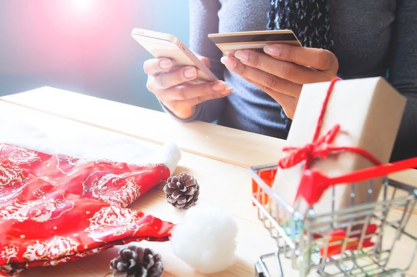 Woman using mobile phone and credit card. Christmas shopping online